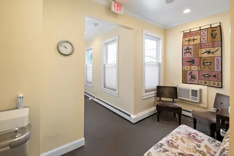 a view of a workspace with furniture and a window