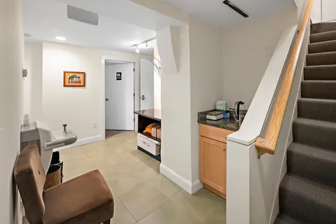 a living room with furniture and a black refrigerator