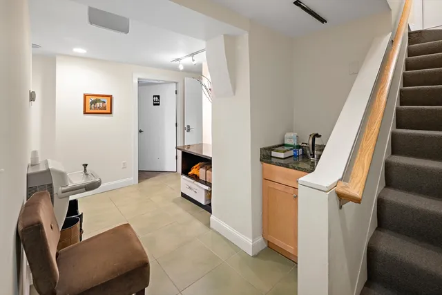 a living room with furniture and a black refrigerator