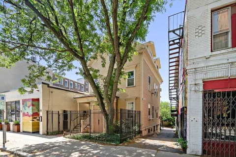 a front view of a house with a tree