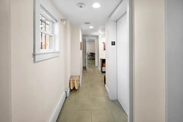 a view of a hallway with closet and a bathroom