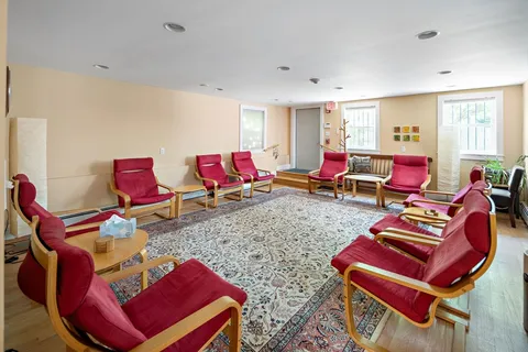 a living room with furniture and red walls