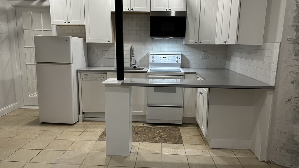 147 Winthrop Road, Unit 2 Brookline, MA 02445 - Photo 18 of 19 a kitchen with stainless steel appliances granite countertop a refrigerator sink and microwave