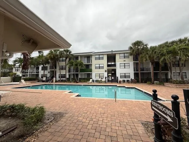 a view of a swimming pool with a patio and a backyard