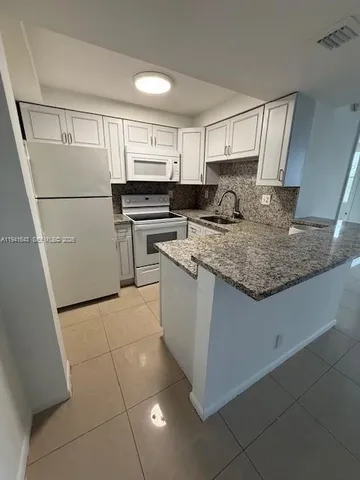 a kitchen with a sink a stove a refrigerator and cabinets