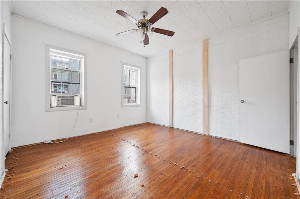 5154-5158 Natrona Way Pittsburgh, PA 15201 - Photo 13 of 46 an empty room with wooden floor ceiling fan and windows