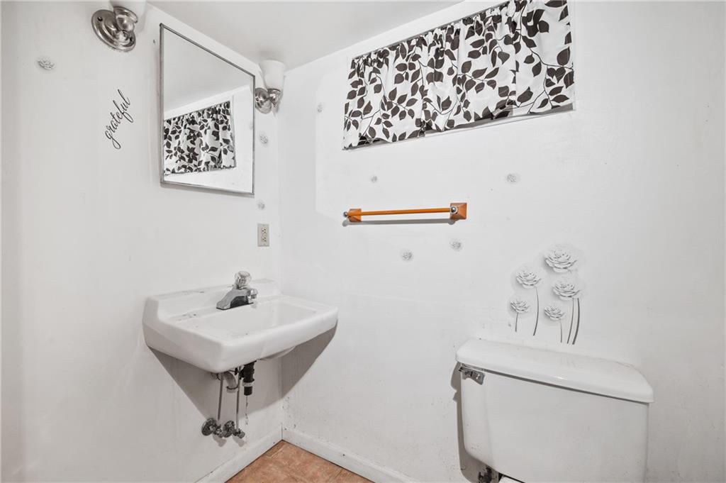 5154-5158 Natrona Way Pittsburgh, PA 15201 - Photo 16 of 46 a bathroom with a sink a mirror and a toilet