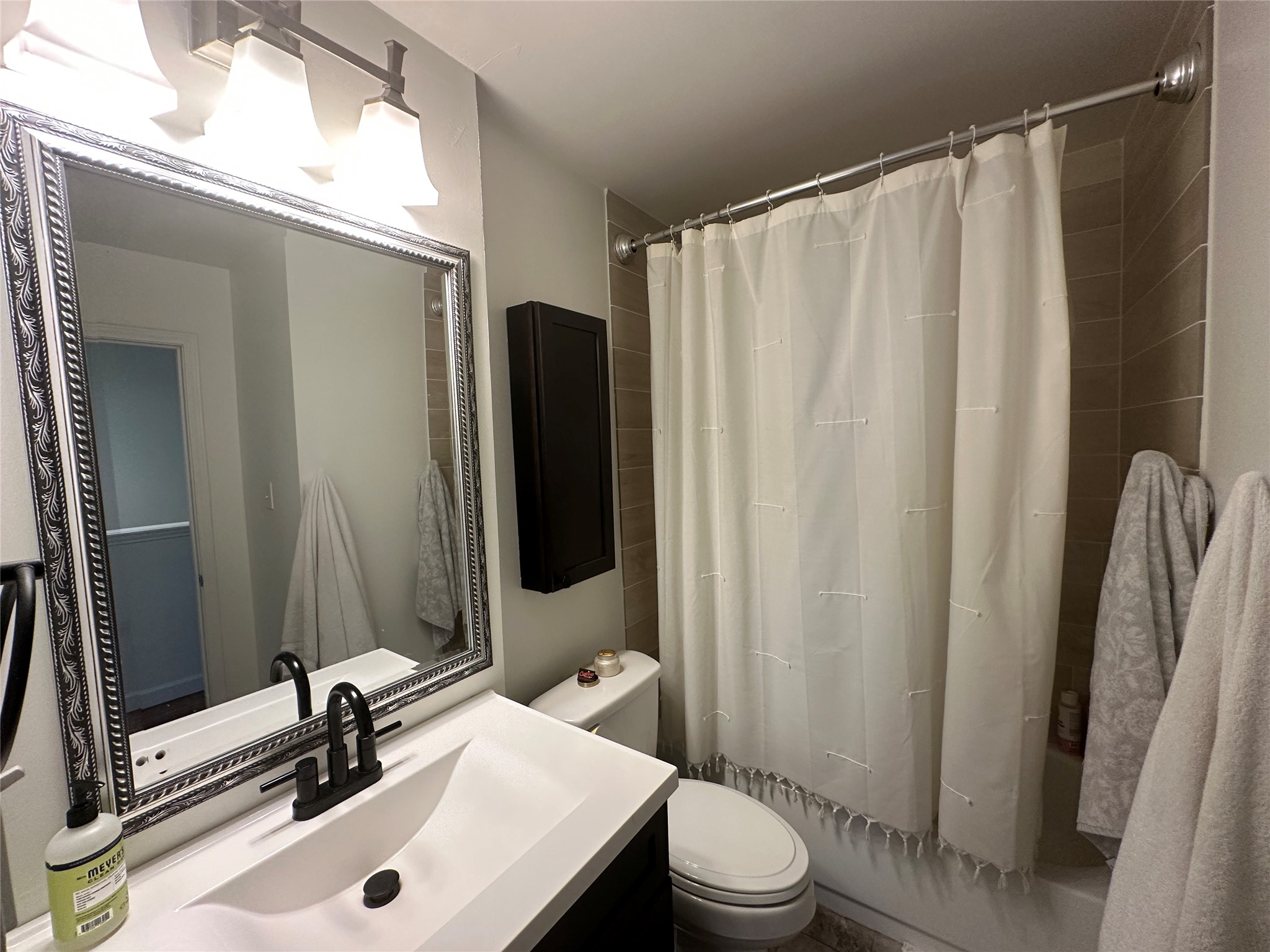 2215 Post Road, Unit 2002 Austin, TX 78704 - Photo 10 of 12 a bathroom with a sink a toilet a mirror and shower curtain
