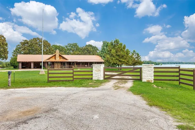a view of a house with a big yard and large trees