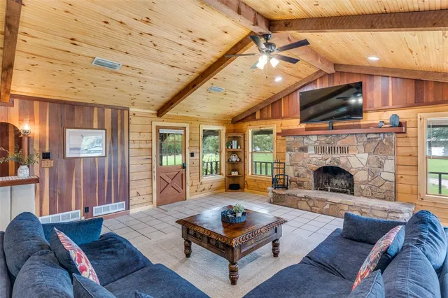 a living room with furniture a flat screen tv and a fireplace