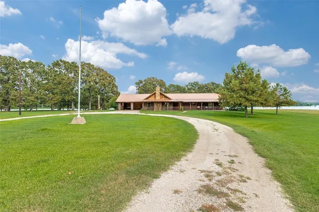 a view of a house with a big yard and a large tree