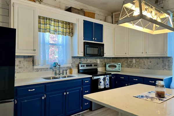 a kitchen with a sink a microwave and cabinets