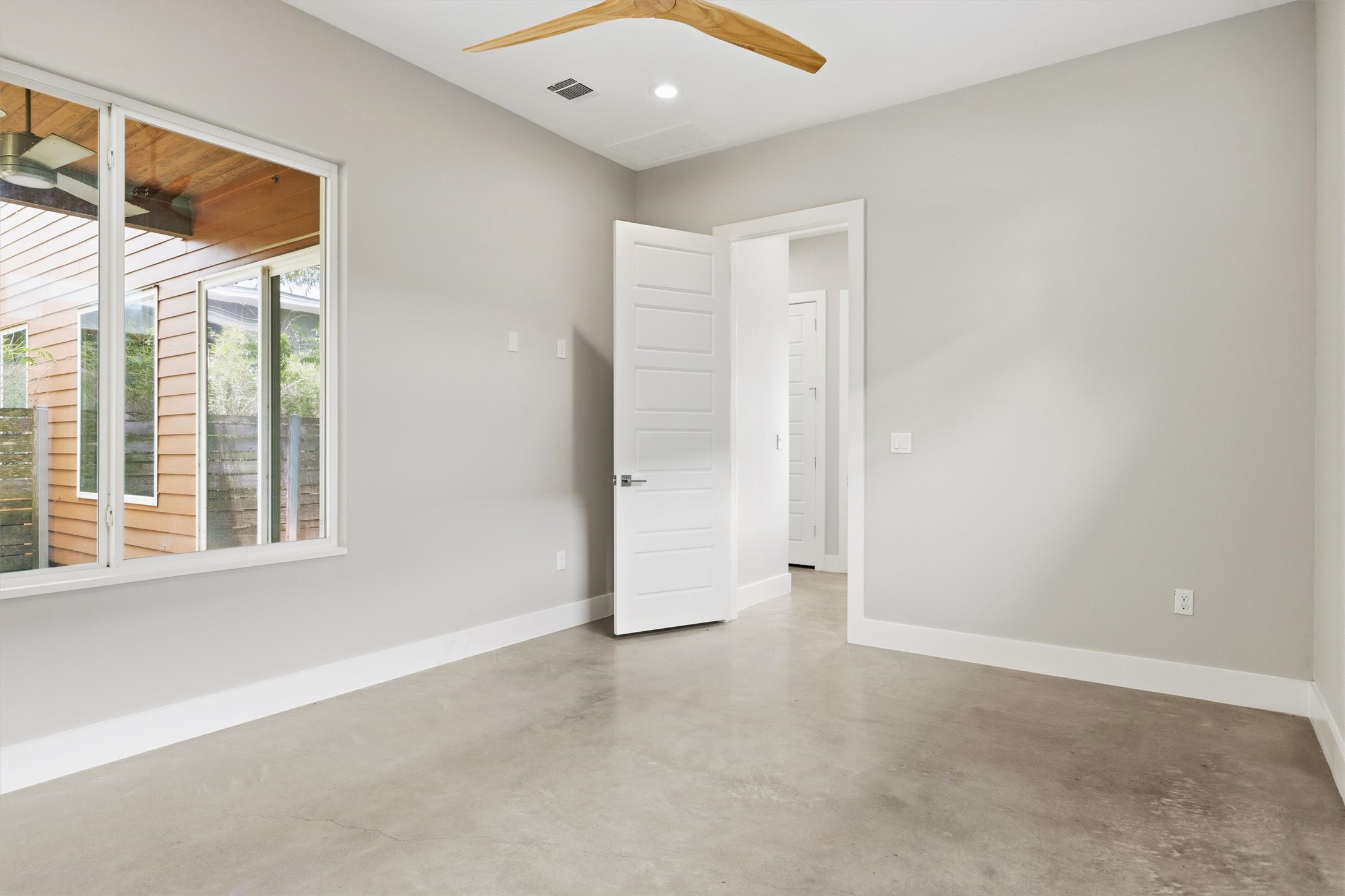 1210 Stobaugh Street, Unit B Austin, TX 78757 - Photo 19 of 40 A tranquil interior space features a sleek wooden ceiling fan and light-toned flooring.