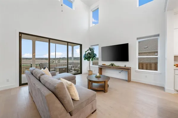 a kitchen with kitchen island a dining table chairs and white cabinets