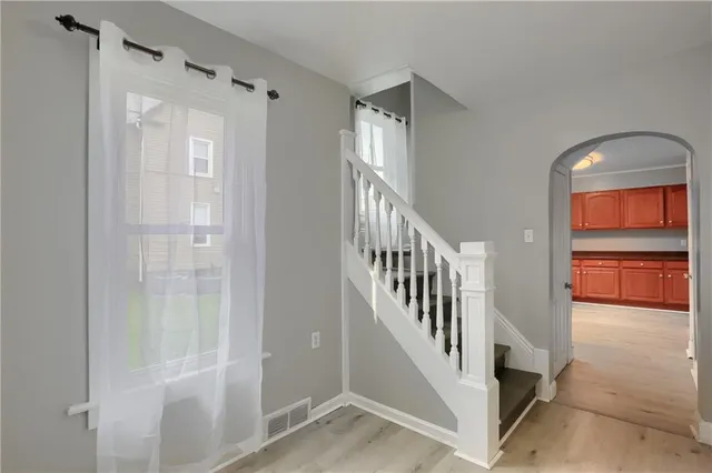 a view of a hallway with a door and stairs