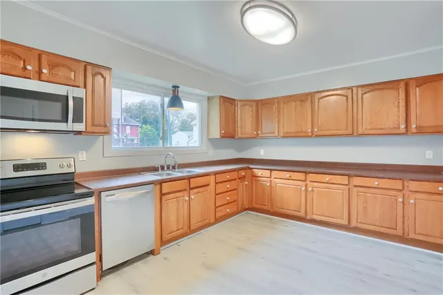 a kitchen with stainless steel appliances granite countertop a stove a sink and a microwave