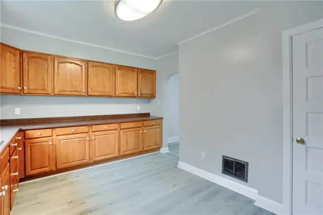 a kitchen with granite countertop cabinets and wooden floor