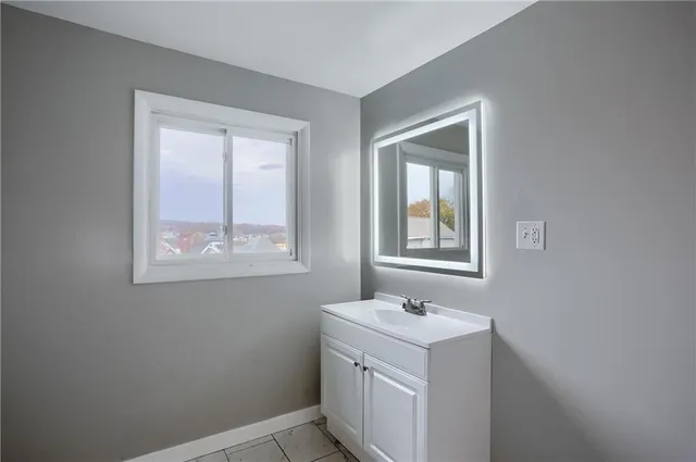 a view of bathroom with a sink cabinets and a window