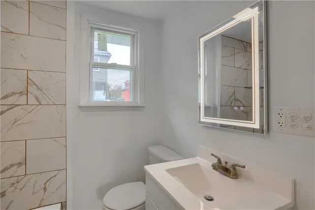 a bathroom with a toilet sink and mirror
