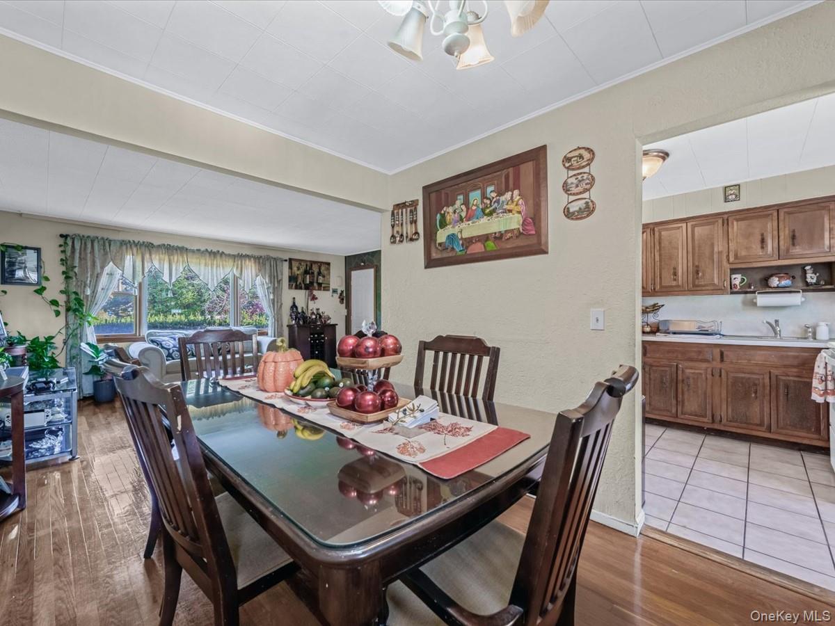 205 Lenox Road Huntington Station, NY 11746 - Photo 6 of 25 Dining area featuring dark wood finished floors, a textured wall, and crown molding