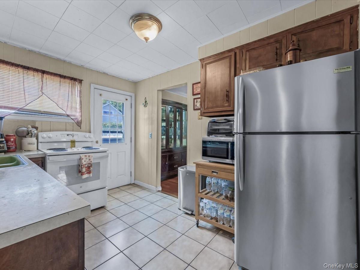 205 Lenox Road Huntington Station, NY 11746 - Photo 8 of 25 Kitchen with appliances with stainless steel finishes, light tile patterned floors, and light countertops