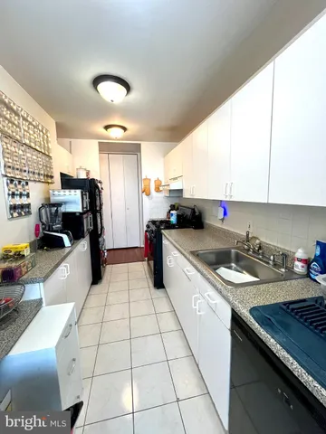 a kitchen with stainless steel appliances a sink a stove a refrigerator and cabinets