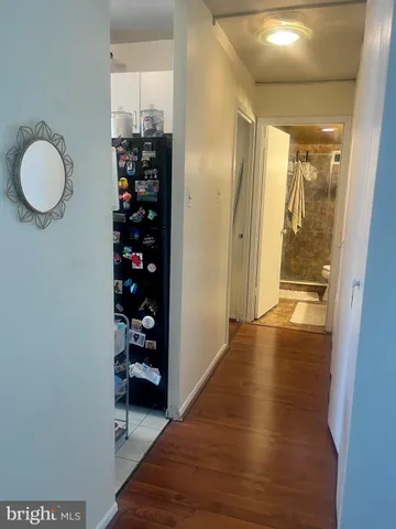 a view of a hallway with wooden floor and closet