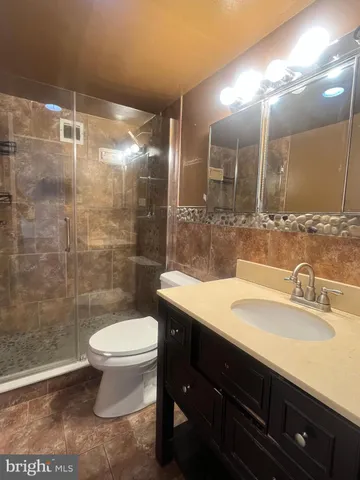 a bathroom with a sink a toilet a mirror and shower