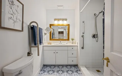 a bathroom with a sink a toilet and a mirror