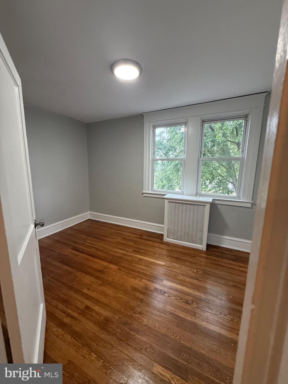 7249 Guilford Road Upper Darby, PA 19082 - Photo 8 of 19 a view of an empty room with wooden floor and a window