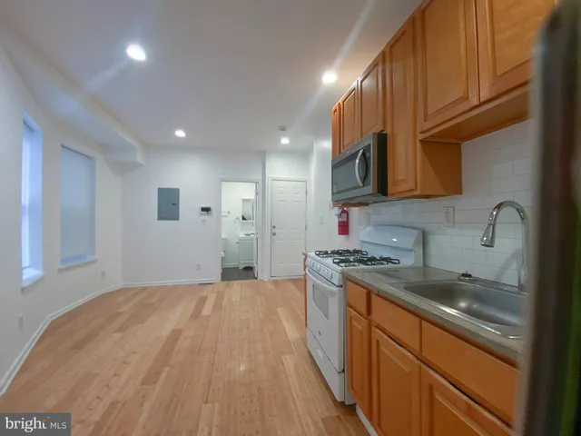 a kitchen with stainless steel appliances granite countertop a sink stove and cabinets