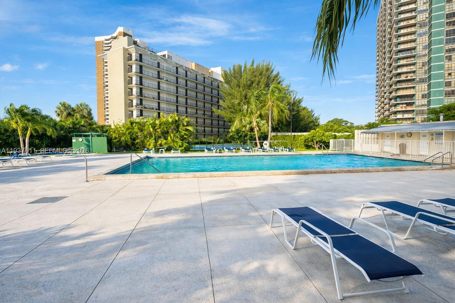 880 Northeast 69th Street, Unit 8M Miami, FL 33138 - Photo 11 of 14 a view of a terrace with a lawn chairs and palm trees