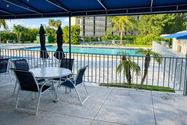a view of a patio with a table chairs and a yard