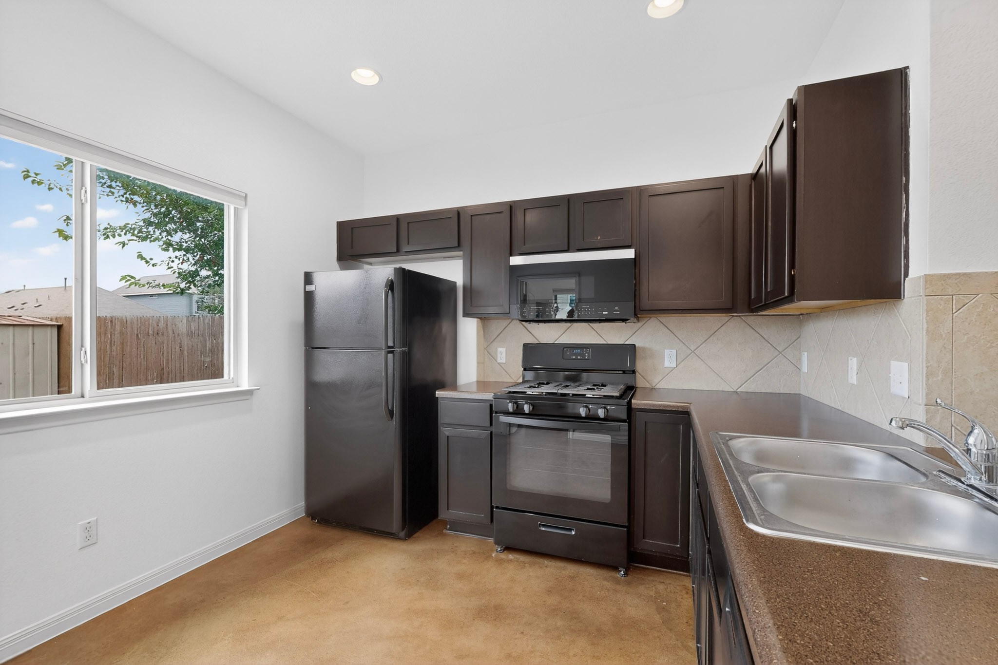 4619 Inicio Lane Austin, TX 78725 - Photo 10 of 32 a kitchen with a refrigerator stove and sink