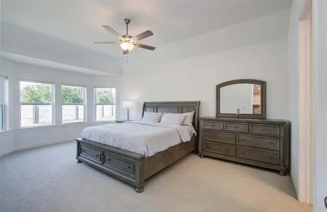 a spacious bedroom with a bed and window