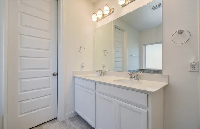 a bathroom with a double vanity sink and a mirror