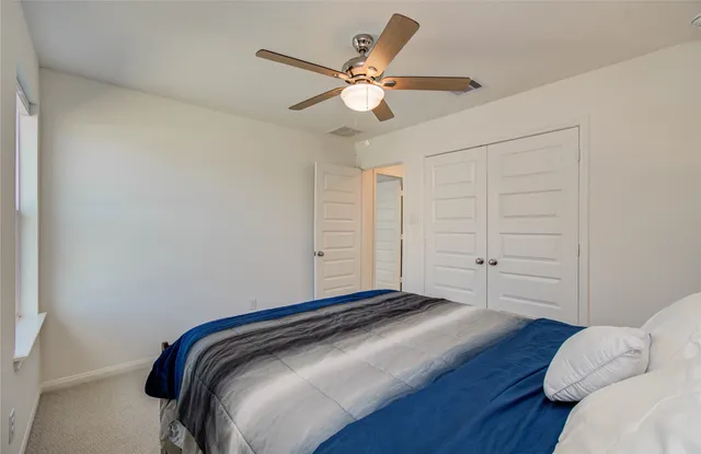 a bedroom with a bed and a ceiling fan