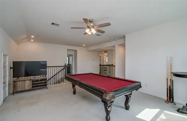 a living room with furniture pool table and a flat screen tv