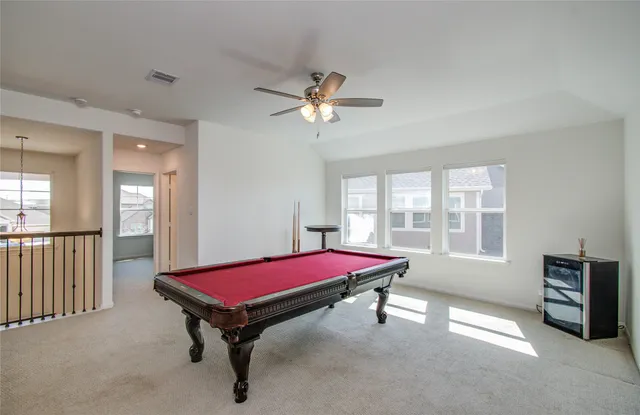 a room with pool table and windows
