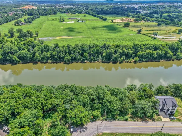 an aerial view of ocean with green space