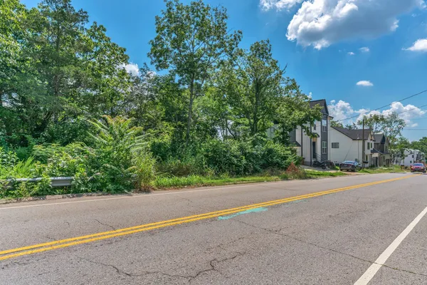 a view of a house with a yard and a street