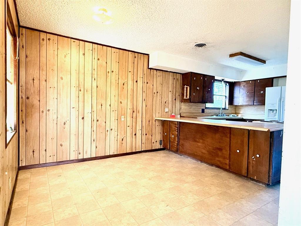1954 East Booth Street Paris, TX 75460 - Photo 3 of 11 a kitchen with stainless steel appliances granite countertop a stove a sink and a refrigerator with cabinets