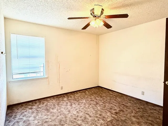 a view of a big room with wooden floor and a chandelier fan