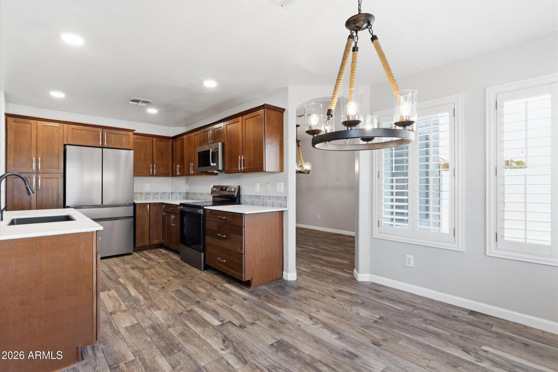 13633 South 47th Street Phoenix, AZ 85044 - Photo 14 of 37 a kitchen with stainless steel appliances granite countertop a stove a refrigerator and a sink