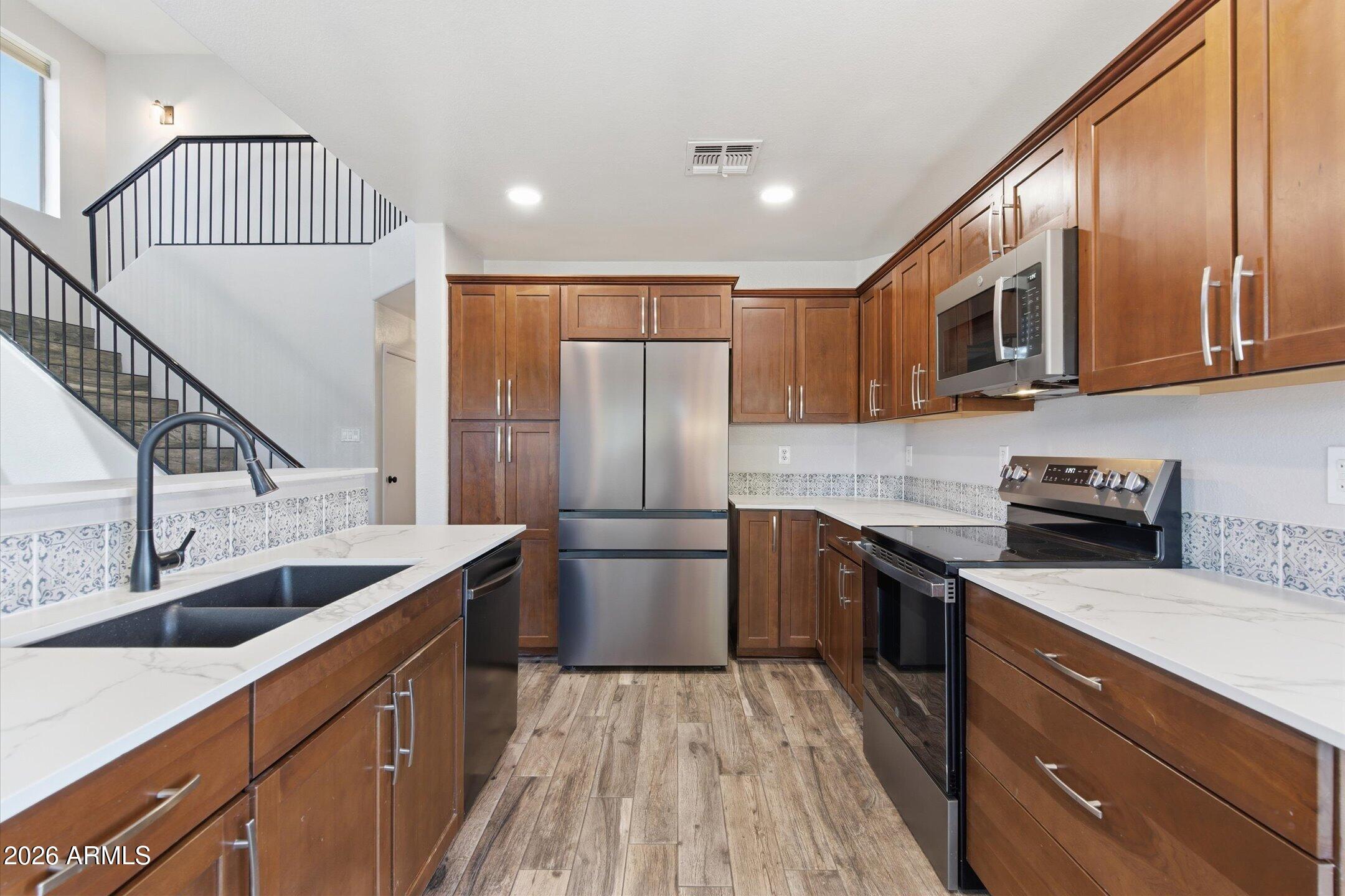13633 South 47th Street Phoenix, AZ 85044 - Photo 15 of 37 a kitchen with stainless steel appliances granite countertop a sink stove and refrigerator