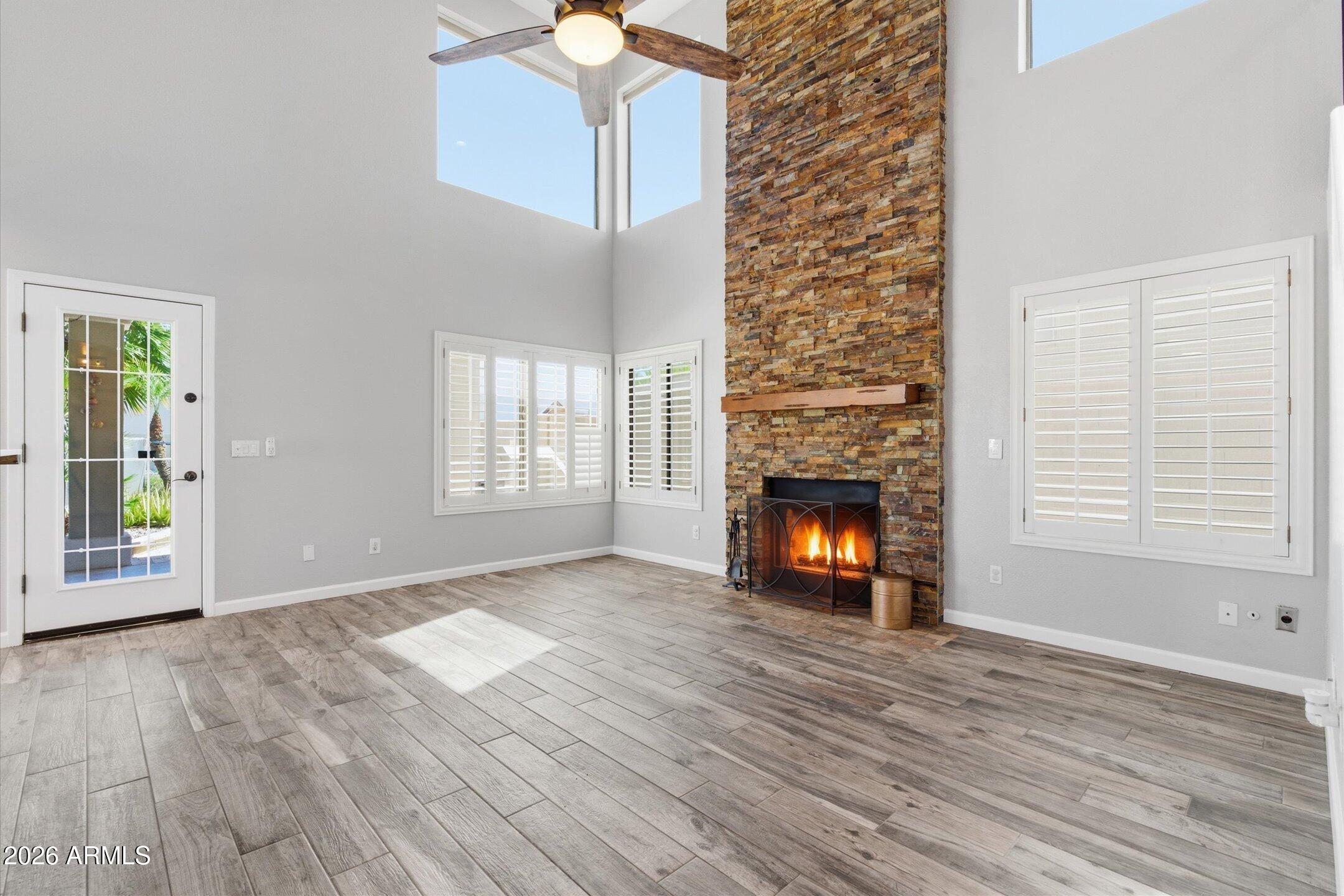 13633 South 47th Street Phoenix, AZ 85044 - Photo 19 of 37 a view of an empty room with wooden floor fire place and windows