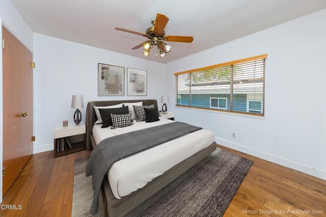 a bedroom with a bed and wooden floor