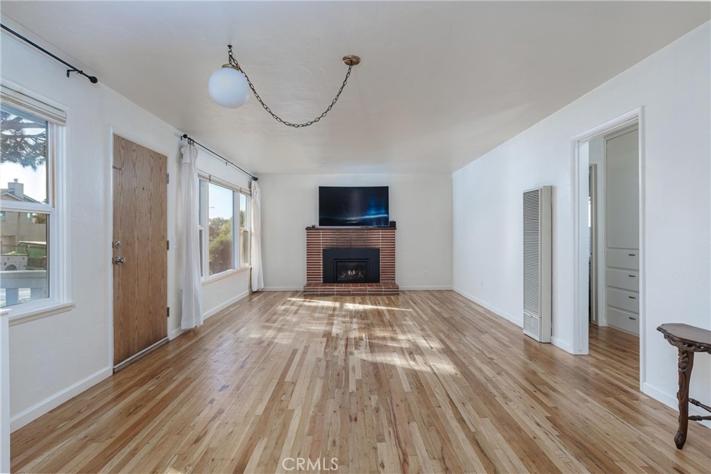 943 Pecho Street Morro Bay, CA 93442 - Photo 6 of 19 a view of empty room with wooden floor and fireplace