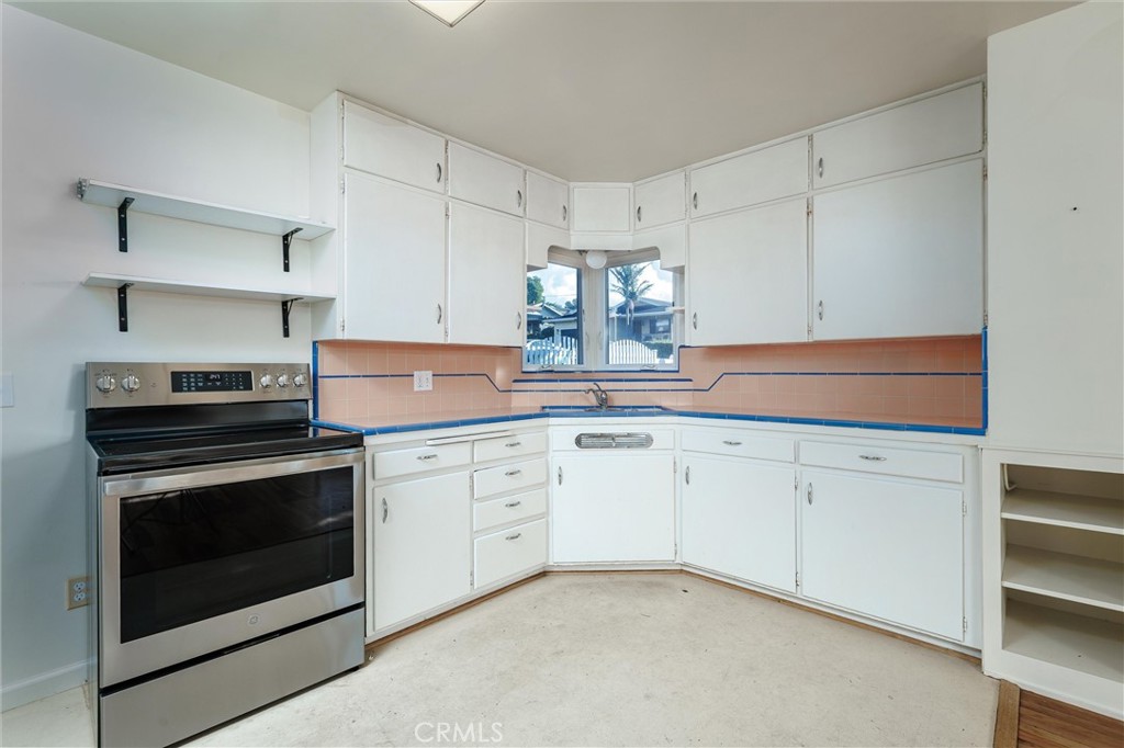 943 Pecho Street Morro Bay, CA 93442 - Photo 9 of 19 a kitchen with granite countertop white cabinets stainless steel appliances and sink