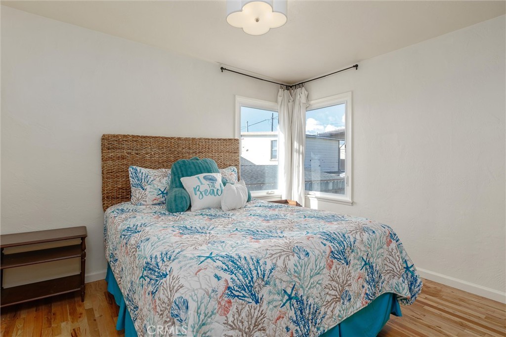 943 Pecho Street Morro Bay, CA 93442 - Photo 10 of 19 a bedroom with a bed and wooden floor